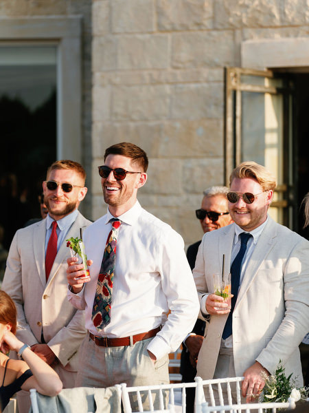 Wedding guests laughing during cocktail hour at Mediterranean luxury resort wedding.