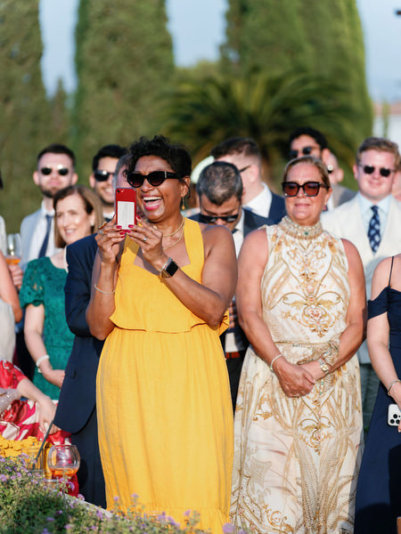 Wedding guests smiling during ceremony at Anassa Hotel Cyprus.