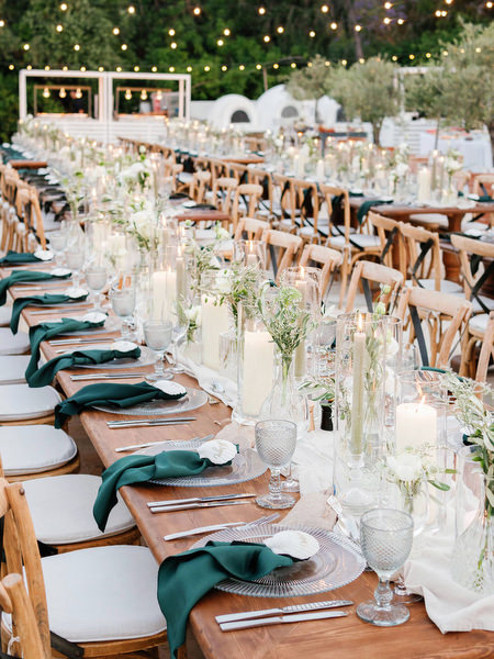 Long wooden reception tables with candles at Anassa Hotel Cyprus wedding.