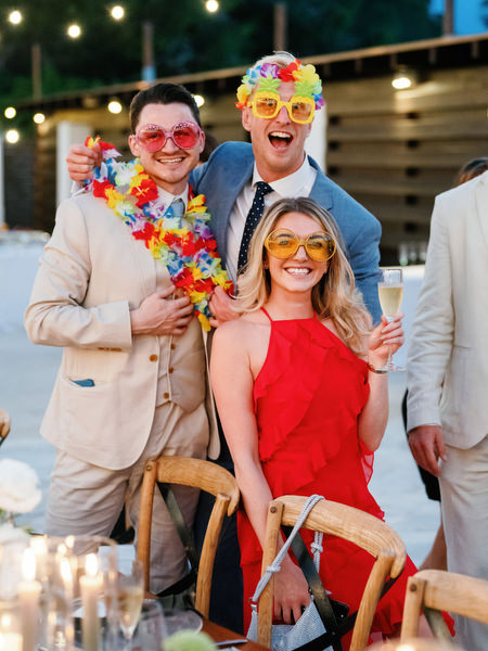 Guests wearing fun party accessories at Anassa Hotel wedding reception.