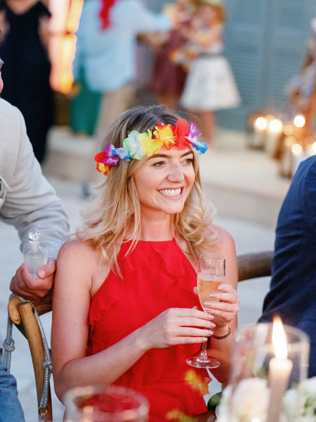 Wedding guest in red dress with floral crown at Anassa Hotel Cyprus.