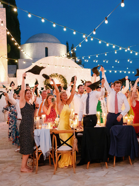 Wedding guests cheering under string lights at Anassa Hotel Cyprus.
