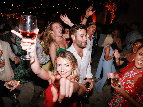 Wedding guests dancing under string lights at Anassa Hotel Cyprus.