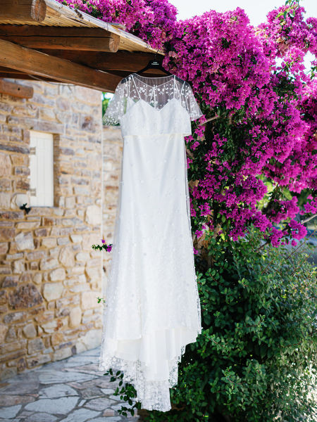 Wedding dress hanging under bougainvillea in Antiparos, Greece.