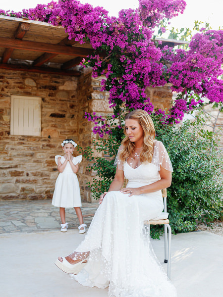 Bride and flower girl portrait in Antiparos beneath bougainvillea.