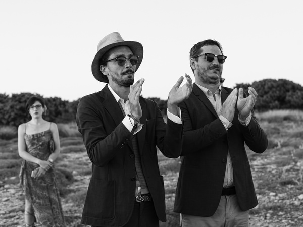 Guests applauding during cliffside wedding ceremony in Antiparos.
