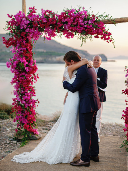 Bride and groom embracing after seaside wedding ceremony in Antiparos.