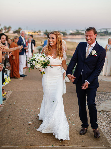 Bride and groom walking down aisle after Antiparos cliffside wedding.