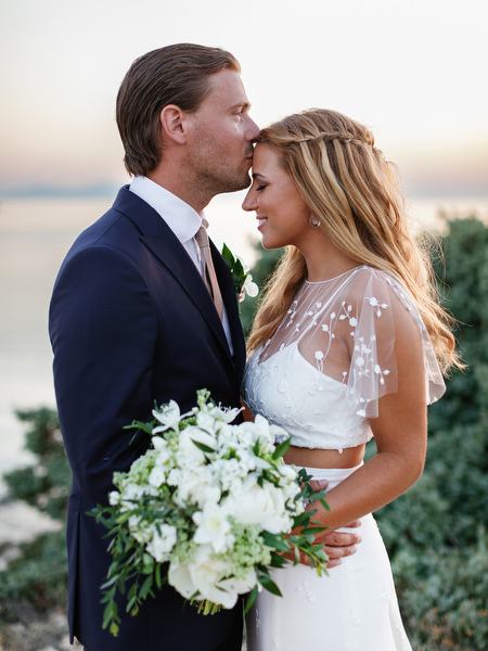 Groom kissing bride’s forehead during sunset portraits in Antiparos.