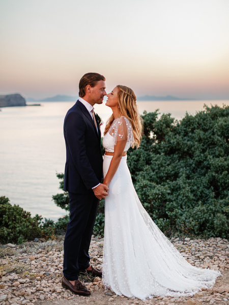 Newlyweds embracing at sunset overlooking the Aegean Sea in Antiparos.