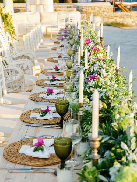 Long outdoor reception table setup in Antiparos with greenery decor.