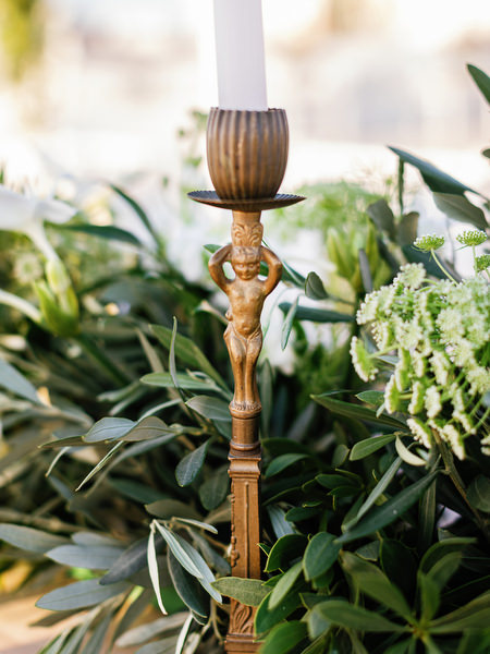 Brass candleholder with greenery at Antiparos destination wedding.