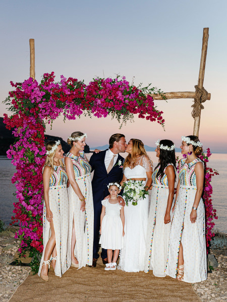 Bridal party under pink bougainvillea arch at Antiparos destination wedding.