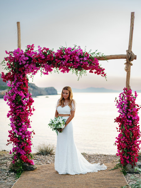 Bride portrait under bougainvillea ceremony arch in Antiparos.