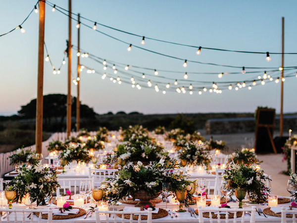 Outdoor wedding reception under string lights in Antiparos at night.