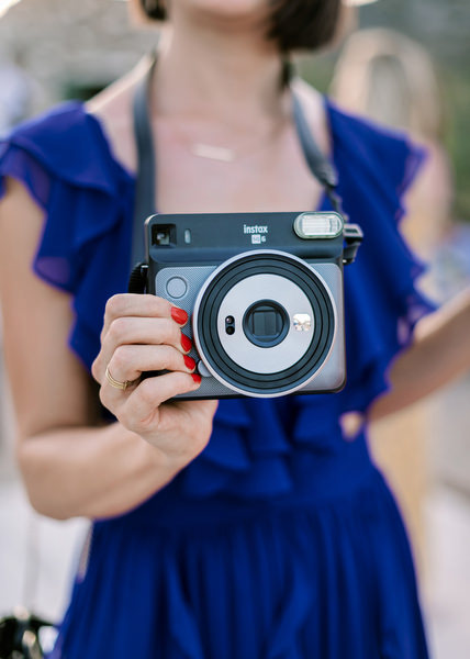 Guest with instant camera at Villa Berenice wedding.