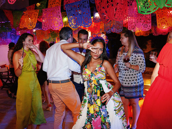 Woman enjoying festive dance floor moment at Antiparos pre-wedding fiesta