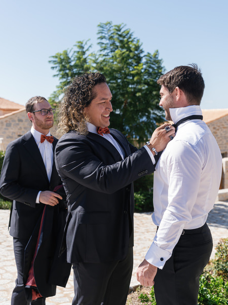 Groomsman adjusting bowtie at Aria Estate wedding in the Peloponnese