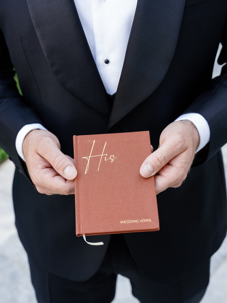 Groom holding wedding vows at Aria Estate destination wedding
