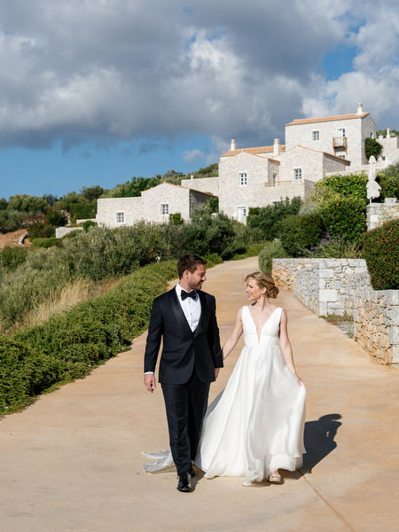 Bride and groom walking through Aria Estate grounds in the Peloponnese