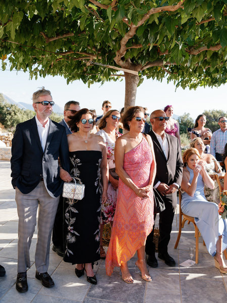 Wedding guests standing during outdoor ceremony at Aria Estate in the Peloponnese