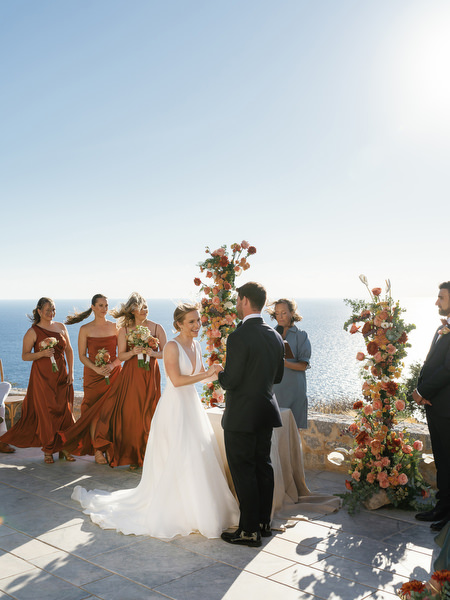 Bride and groom at floral ceremony arch at Aria Estate Greece