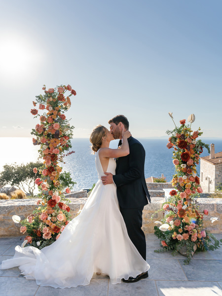 First kiss at Aria Estate wedding ceremony with sea backdrop