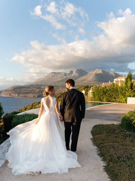 Bride and groom walking at Aria Estate with sea and mountain views
