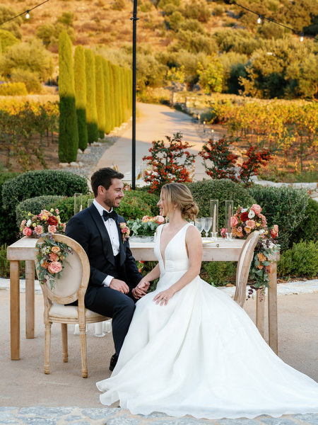 Bride and groom at floral sweetheart table at Aria Estate wedding in Greece