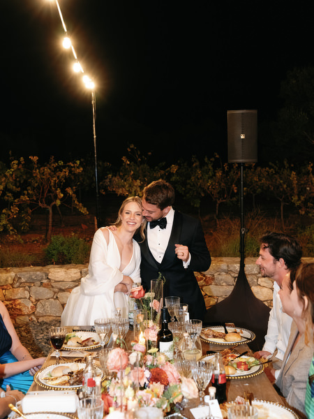 Bride and groom enjoying dinner at Aria Estate night reception in Greece