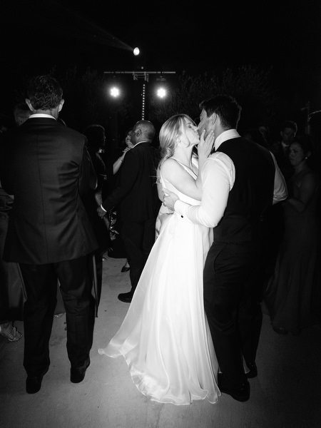 Bride and groom kiss during Aria Estate night party