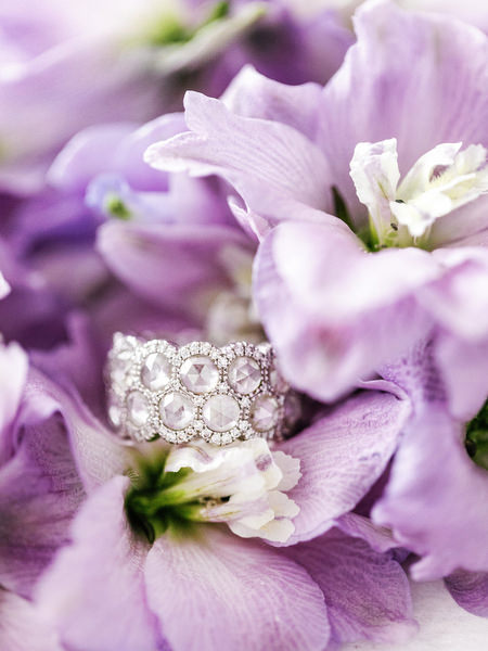 Bridal diamond ring resting on lilac florals during a luxury Athens Riviera wedding at Four Seasons Astir Palace