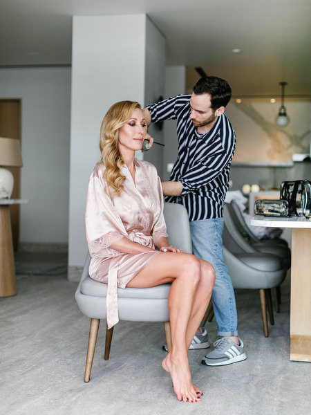 Bride getting ready during a luxury Athens wedding at Four Seasons Astir Palace, with hairstyling inside a seaside suite on the Athens Riviera