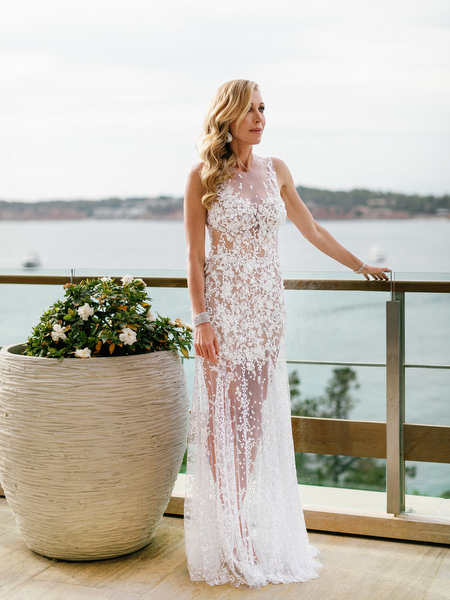 Bride in couture lace gown posing on a sea-view balcony during her Athens wedding at Four Seasons Astir Palace