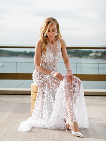 Bride adjusting her couture wedding dress on a balcony at Four Seasons Astir Palace before her Athens Riviera wedding