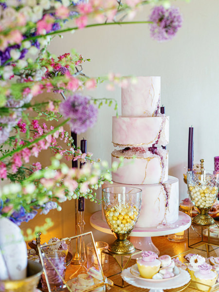 Wedding cake surrounded by lilac florals during an opulent Athens Riviera wedding at Island Resort Athens Riviera, Greece