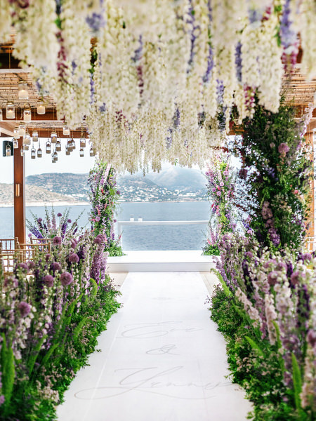 Ceremony aisle framed with cascading blooms and sea views during an Athens Riviera wedding at Island Resort Athens Riviera