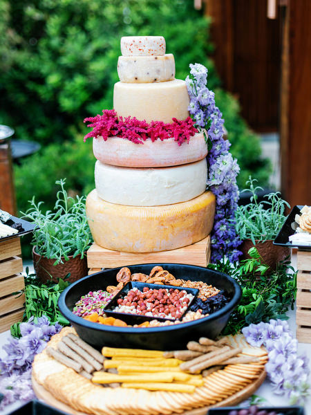 Three-tier cheese tower surrounded by purple blooms at a luxury Island Resort Athens Riviera wedding on the Athens Riviera