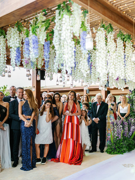 Guests gathered beneath cascading florals during a couture Athens wedding ceremony at Island Resort Athens Riviera