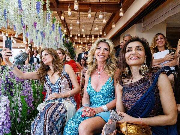 Guests smiling beneath floral décor at a glamorous Athens wedding at Island Resort Athens Riviera