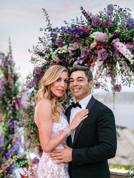Close-up couple portrait against a sea-view floral arch at a luxury Athens wedding at Island Resort Athens Riviera