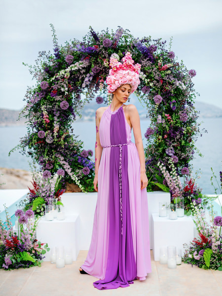 Couture model in lilac gown posing beneath a circular floral arch at an Island Resort Athens Riviera wedding