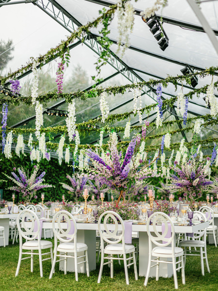 Clear marquee reception setup with cascading wisteria florals at a refined Athens Riviera wedding at Island Resort Athens Riviera