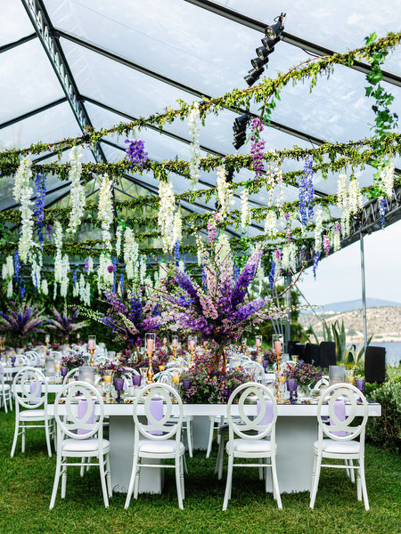 Reception tables framed with lavender and green florals at a Mediterranean-style Athens Riviera wedding