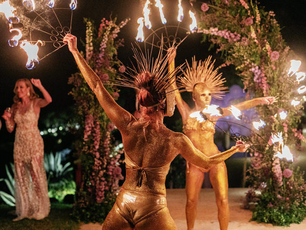 Evening entertainment with fire show beneath floral arches at an Island Resort Athens Riviera Riviera wedding