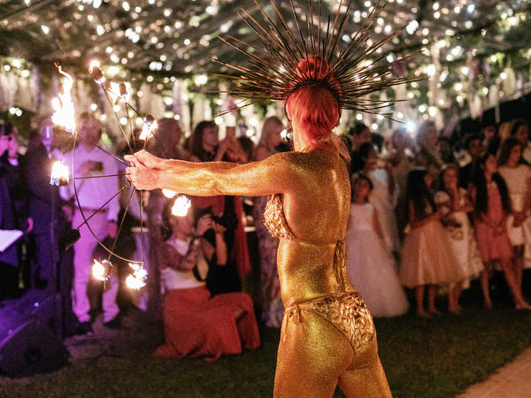 Gold-painted fire performer entertaining guests at night during a luxury Athens wedding at Island Resort Athens Riviera on the Athens Riviera