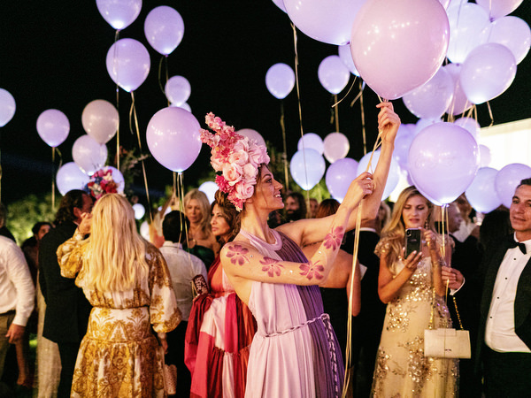 Guests celebrating with lavender balloons during a couture Athens wedding party at Island Resort Athens Riviera