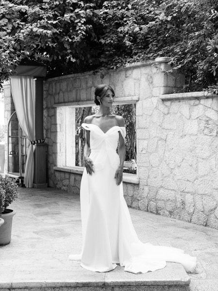 Bride in off-the-shoulder wedding gown posing at Margi Luxury Hotel during black-tie wedding morning