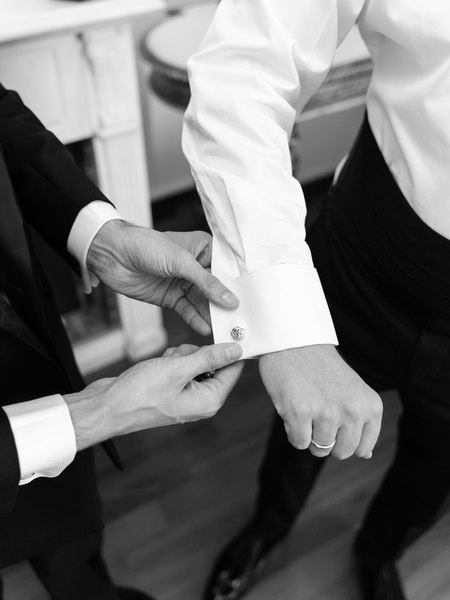 Close-up of groom fastening cufflinks before Four Seasons Astir Palace ceremony