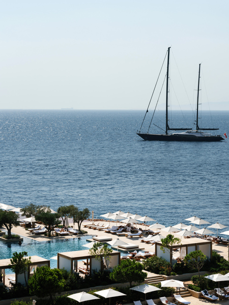 Luxury yacht sailing across the Mediterranean Sea beside Four Seasons Astir Palace Athens
